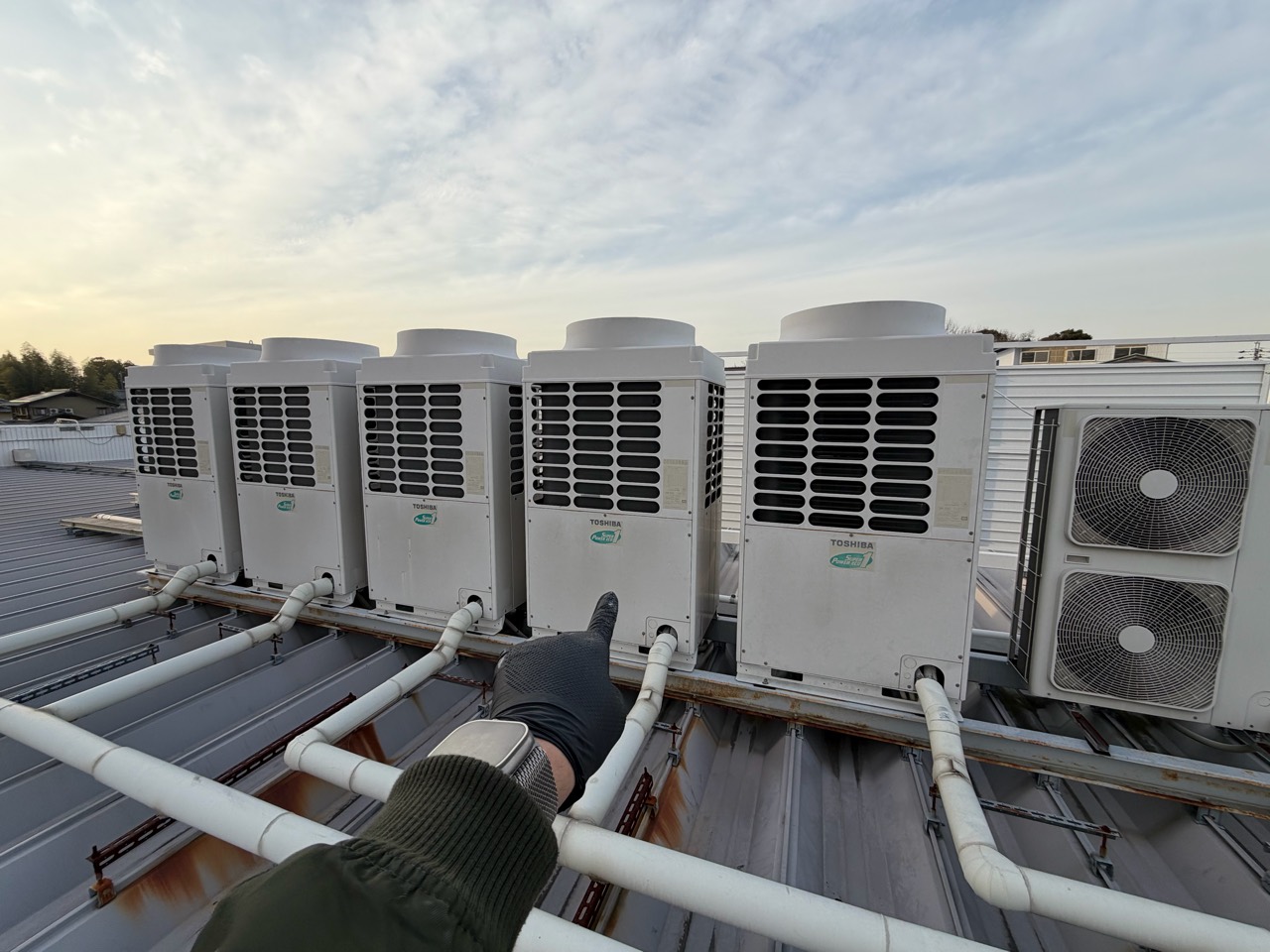 屋上に並ぶ業務用空調の室外機と配管